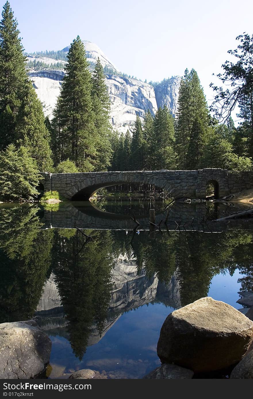 A bridge and nature reflects in the water. A bridge and nature reflects in the water