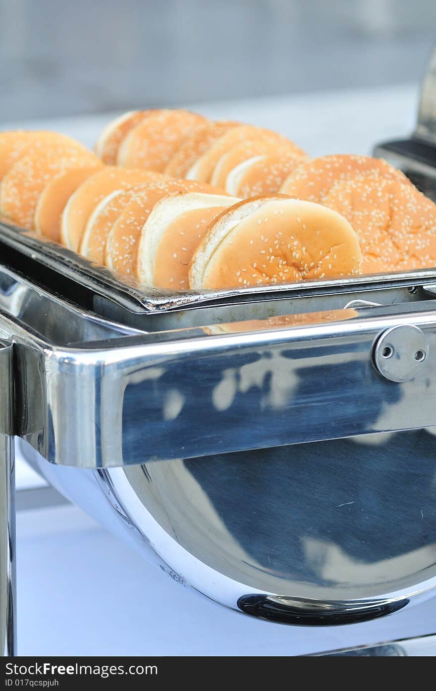 Sesame buns for burgers served in a catering dish. Sesame buns for burgers served in a catering dish