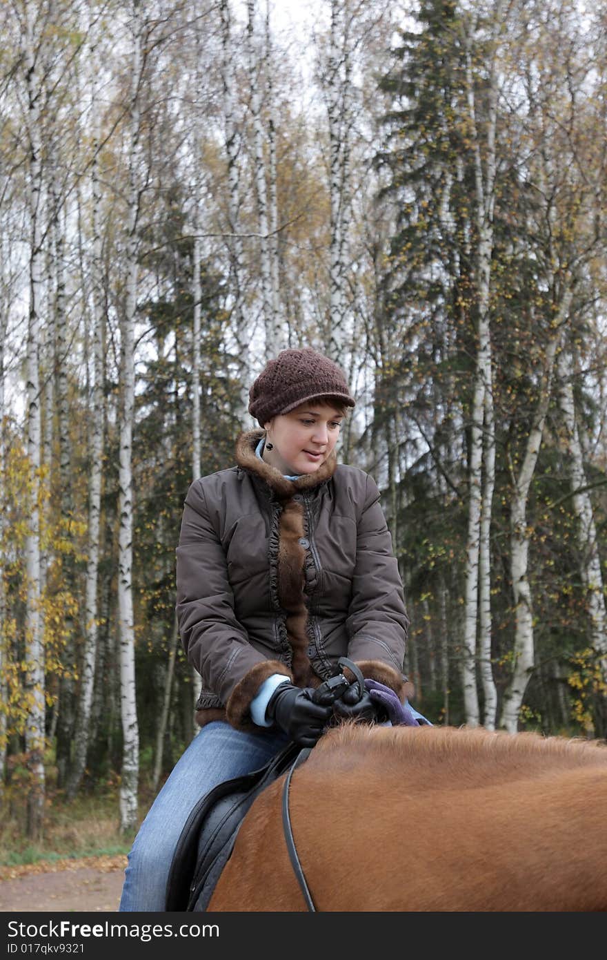 The horsewoman on ride in forest, autumn