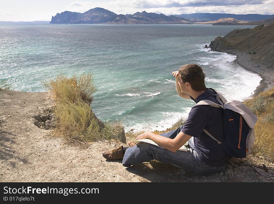 Man with backpack and map in a mountain. Man with backpack and map in a mountain