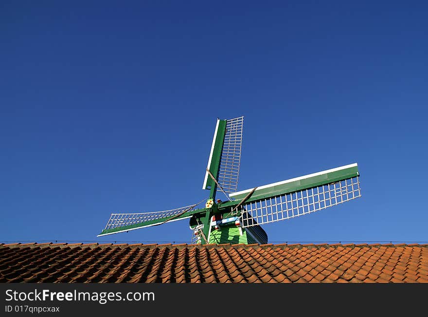 Windmill and red tiles in blue sky