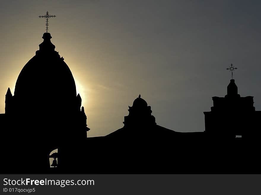 Three mission towers silhouettes against sun