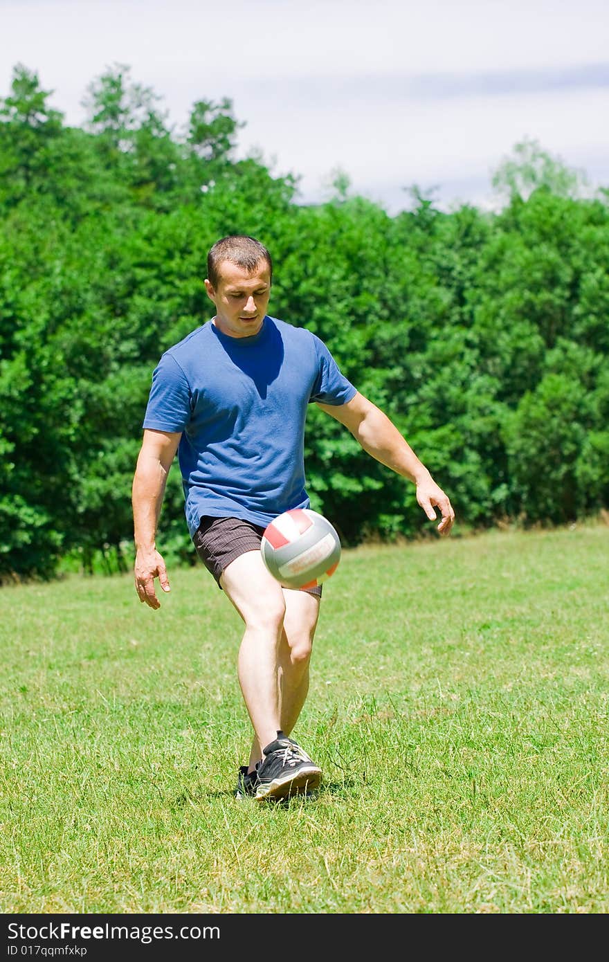 Soccer player kicking the ball over a green background