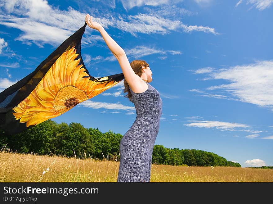 Beautiful woman with orange scarf in a meadow field