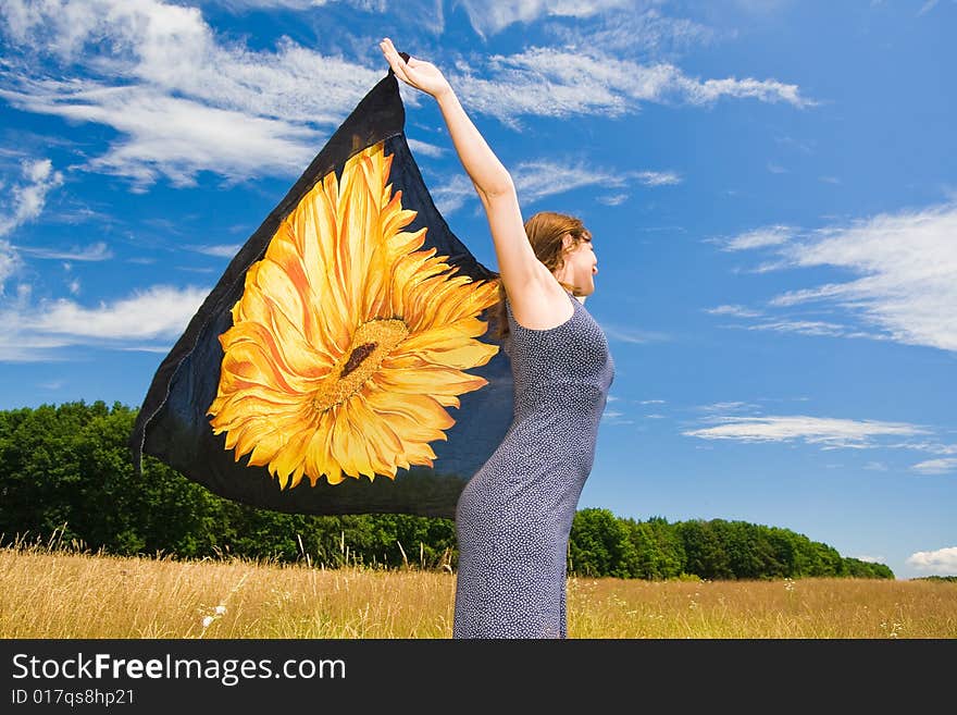 Beautiful woman with orange scarf in a meadow field