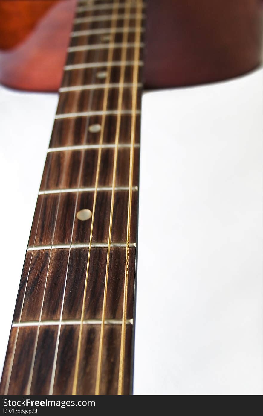 Closeup of a acoustic guitar fretboard on a white background