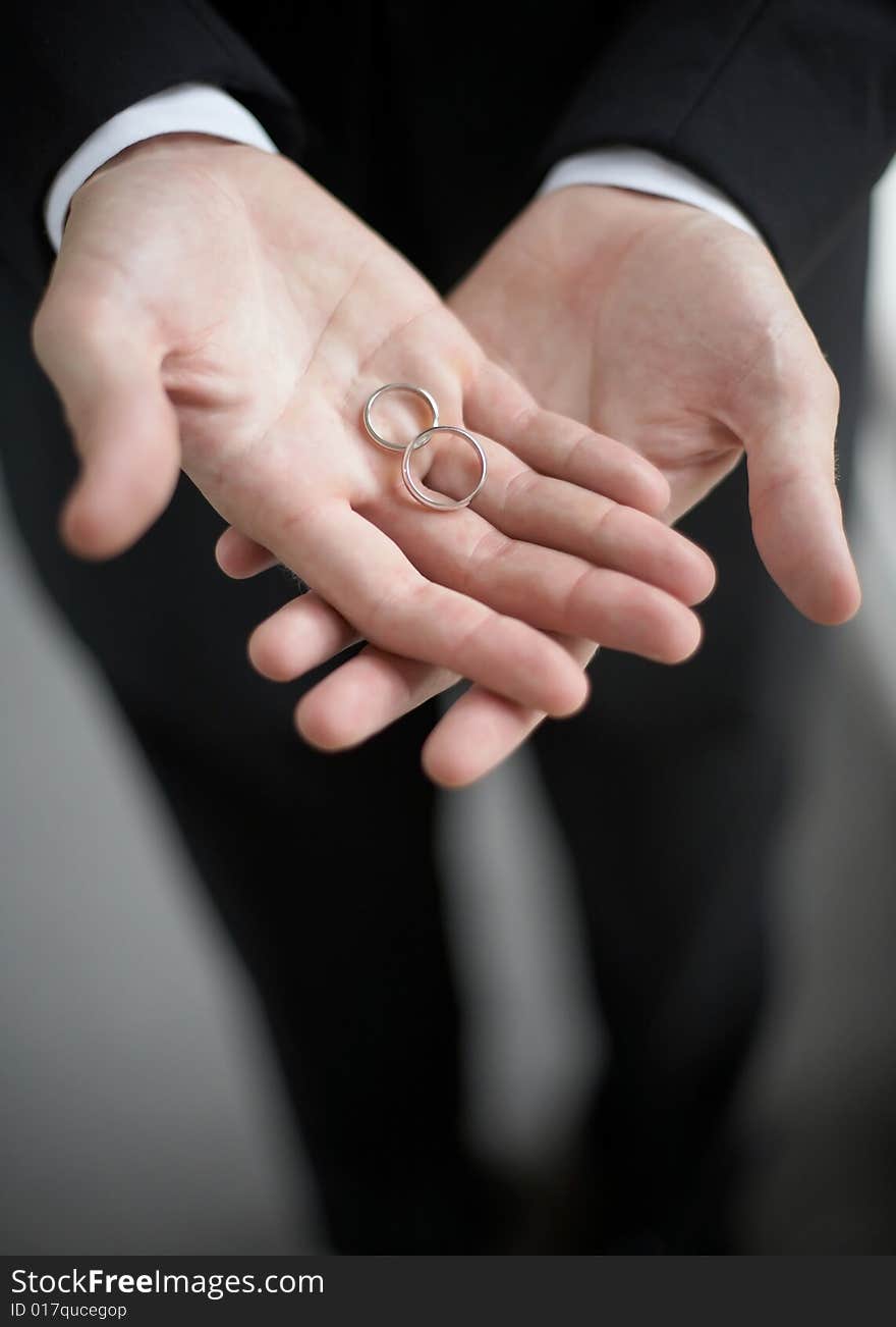 Hands holding wedding bands DOF focus on rings. Hands holding wedding bands DOF focus on rings