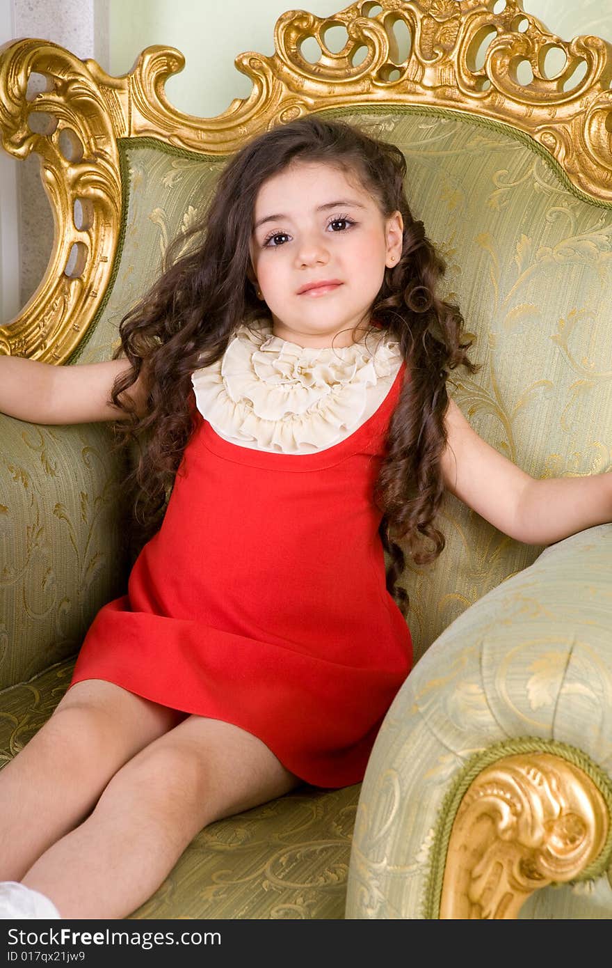 Small girl with long hair in the armchair. Small girl with long hair in the armchair