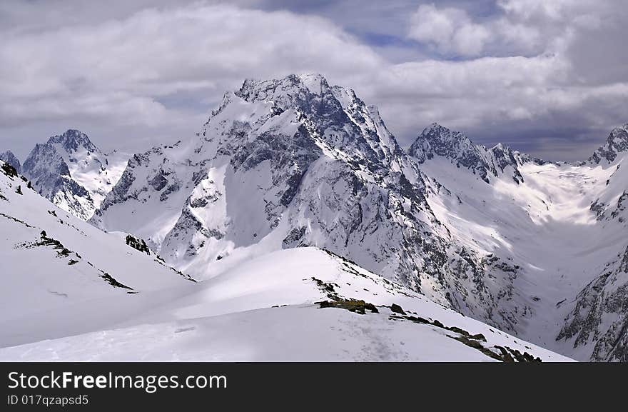 High-mountainous landscape shined by the sun through holes in clouds of a spot of light on a snow.Mountain track. 
Snow way.
Traces of the person in mountains. High-mountainous landscape shined by the sun through holes in clouds of a spot of light on a snow.Mountain track. 
Snow way.
Traces of the person in mountains.