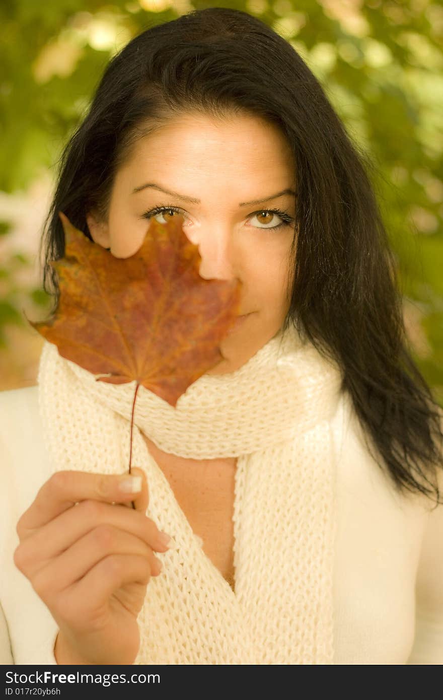 Woman holding a leaf with white scarf. Woman holding a leaf with white scarf