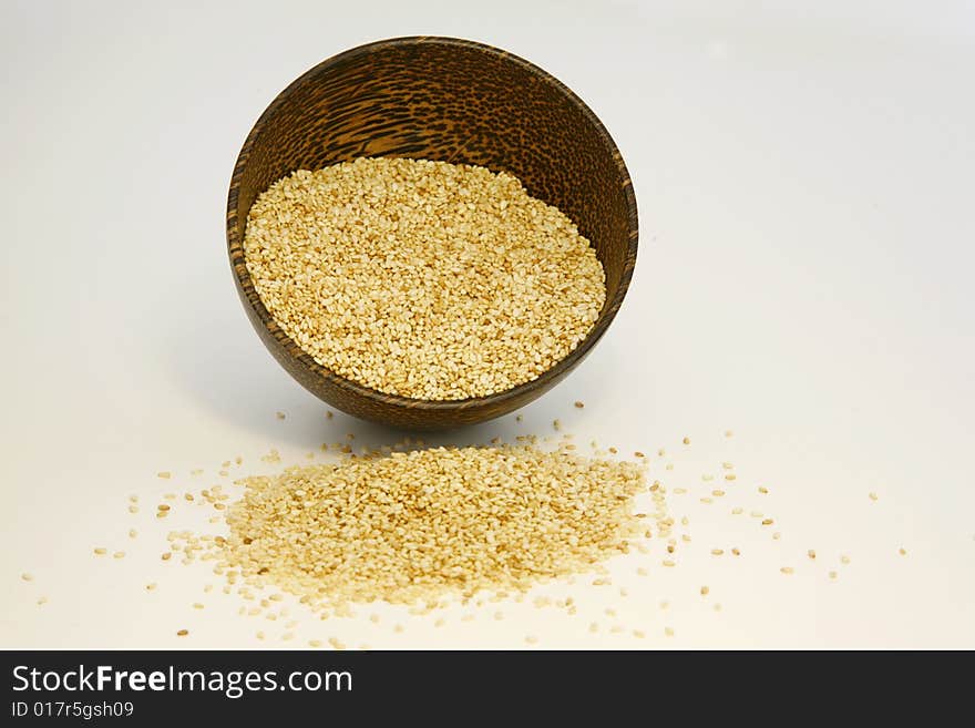 Sesame seeds in coconut bowl isolated on white background. Sesame seeds in coconut bowl isolated on white background