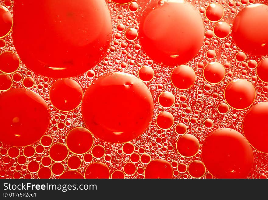 Abstract red looking oil and water bubbles of various sizes