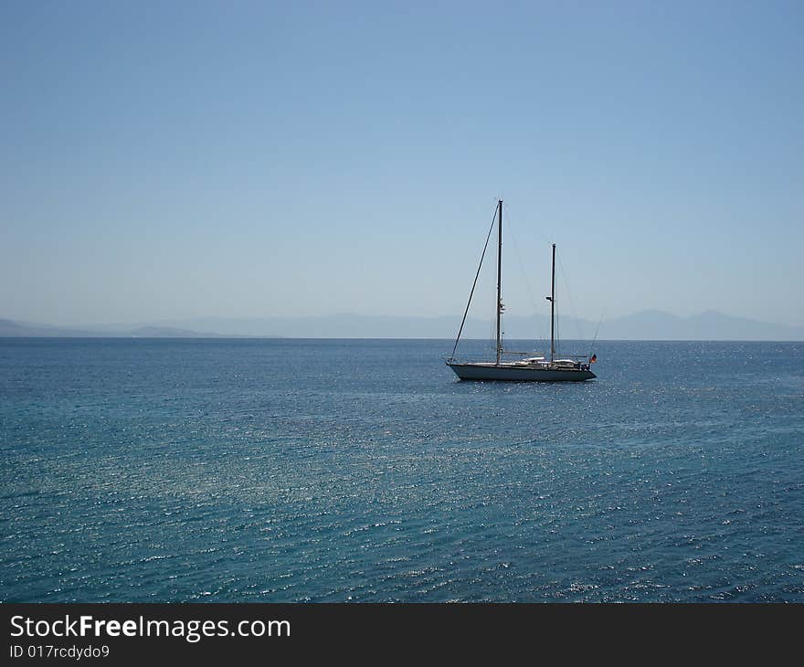 Small boat anchored in a gulf of a Mediterranean coast of Turkey on a perfect summer day. Small boat anchored in a gulf of a Mediterranean coast of Turkey on a perfect summer day