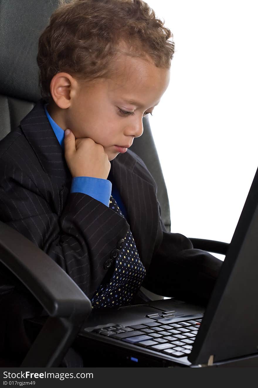 Young boy dressed as businessman with laptop