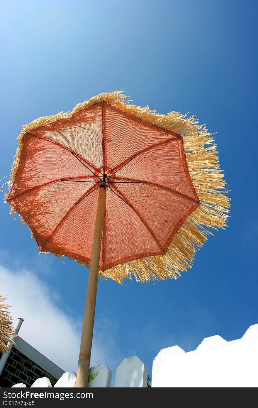 Orange umbrella on the beach and windy weather