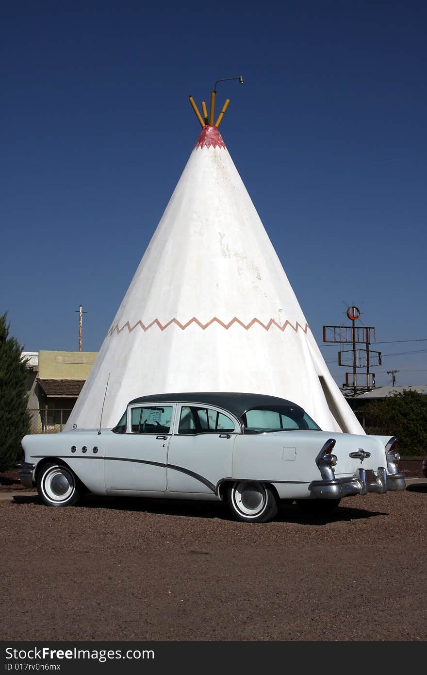 A wigwam bulding with period car