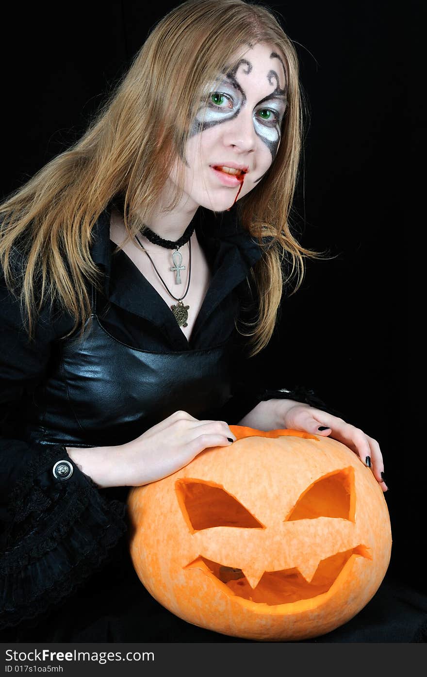 Halloween bloody vampire with pumpkin, on black background