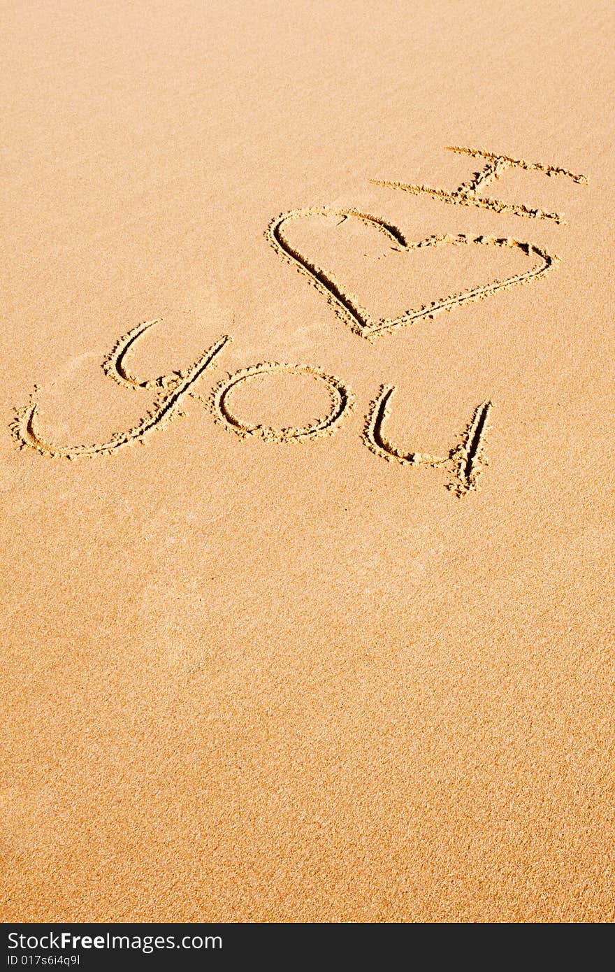 Love phrase written in the sand