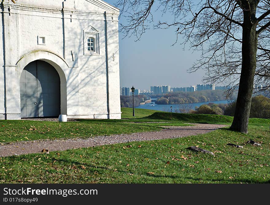 On river bank the fragment of an ancient building, on a background residential buildings is visible