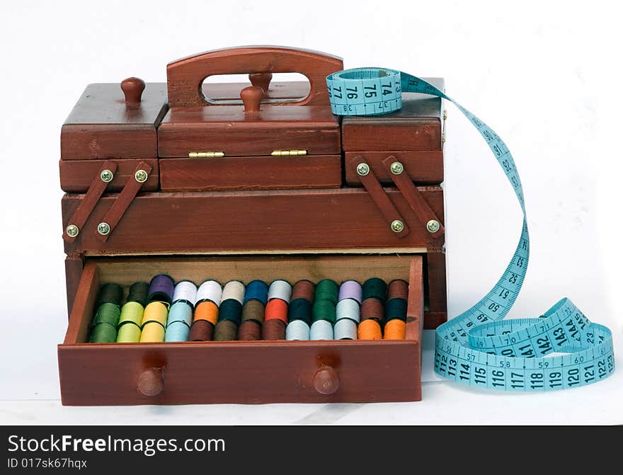 Wooden drawers with spools of colorful threads and measuring tape. Wooden drawers with spools of colorful threads and measuring tape