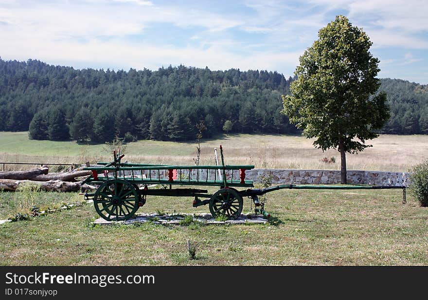 Wooden Cart against background a hill and woods