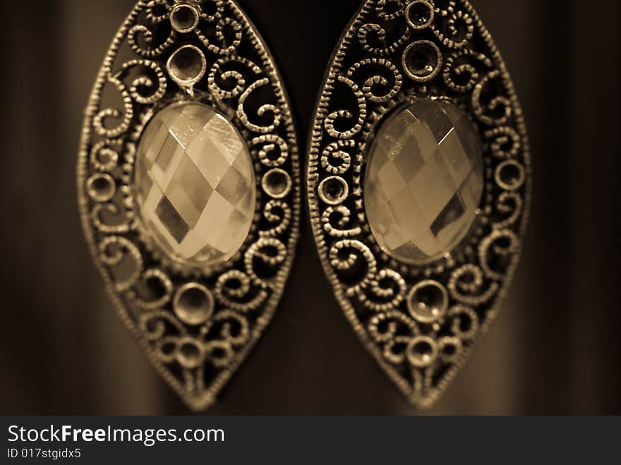 Golden ear rings with jems isolated on black background. Golden ear rings with jems isolated on black background.