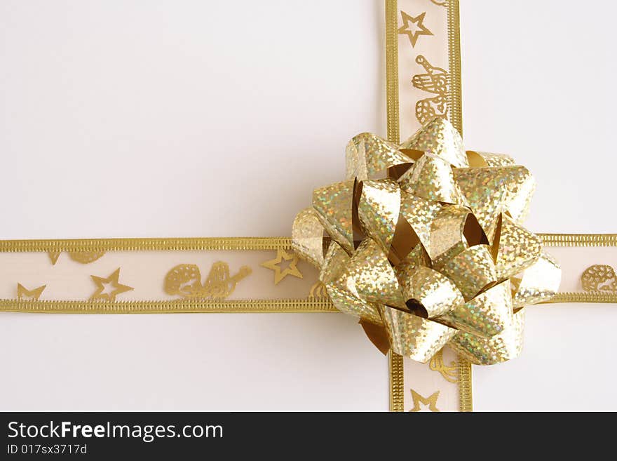 Golden lace and shiny bow on present. Golden lace and shiny bow on present