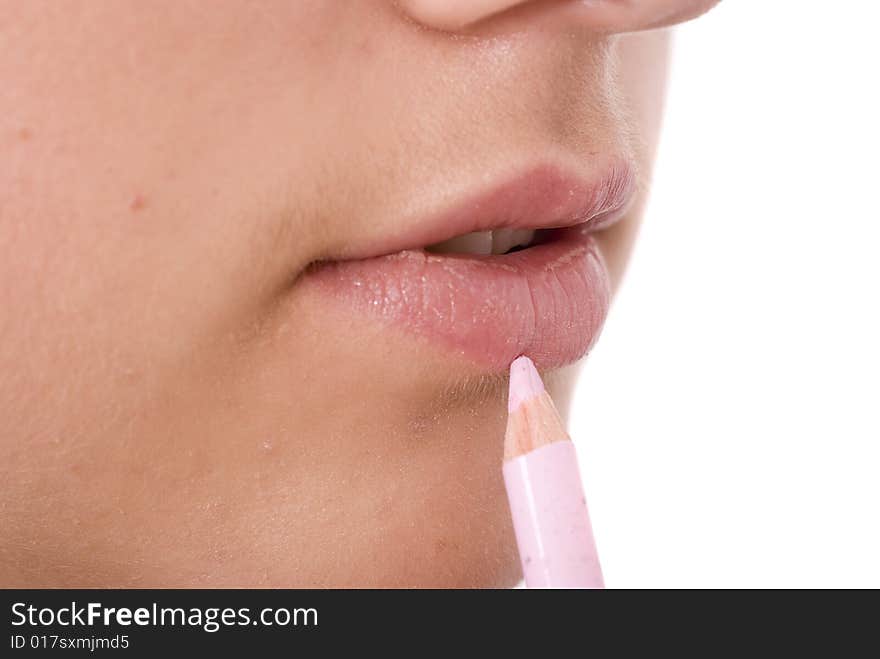 Girl drawing a lip line with pink pencil