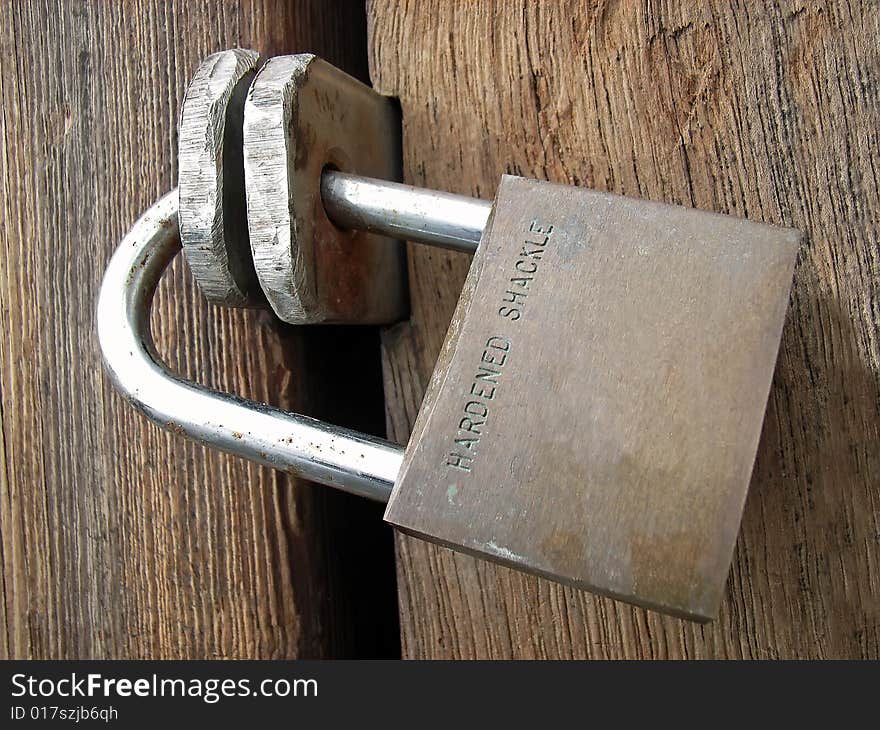 Padlock closing a wooden door. Padlock closing a wooden door