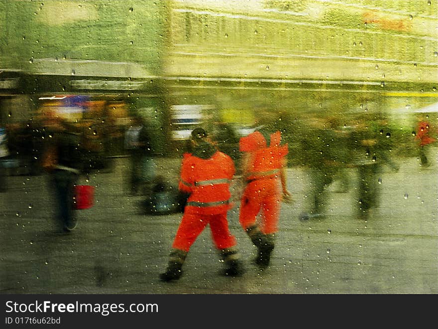 Two red men.
Blurred people walking fast home from job.
Be reflected in gold mirror with raindrops.