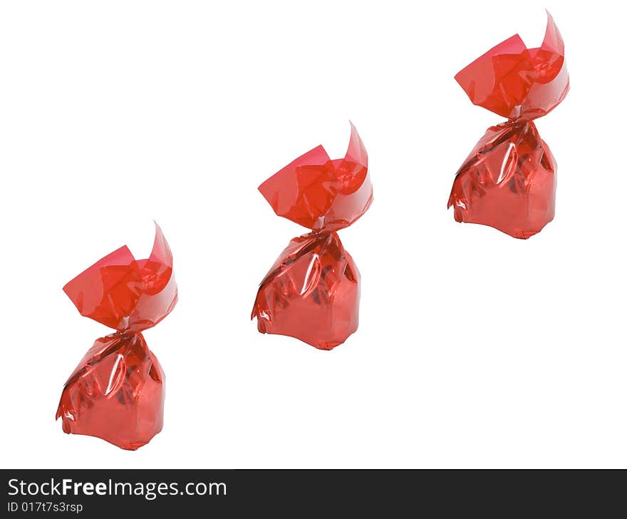 Three pieces of sweets in red wrappers - confectionery - close up. Three pieces of sweets in red wrappers - confectionery - close up