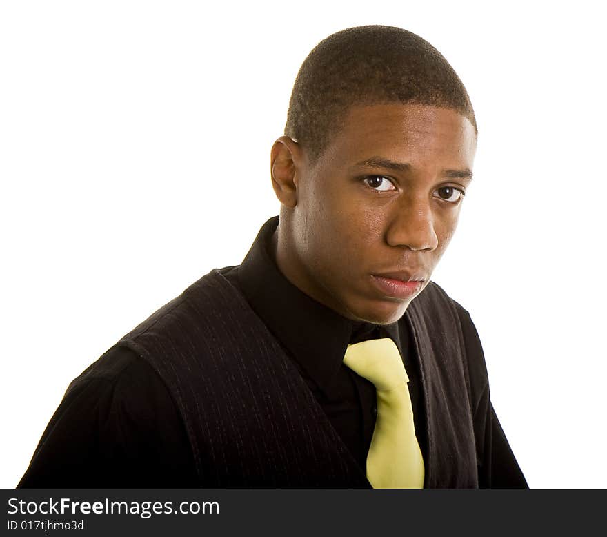 A young black man in black shirt and yellow tie with a serious expression. A young black man in black shirt and yellow tie with a serious expression