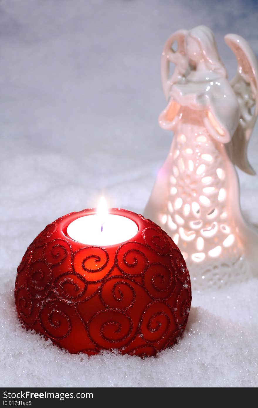 An image of glass balls with candle on snow