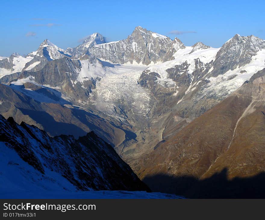 Beatiful panoramic mountain range under blue sky and above deep alpin valley . Beatiful panoramic mountain range under blue sky and above deep alpin valley