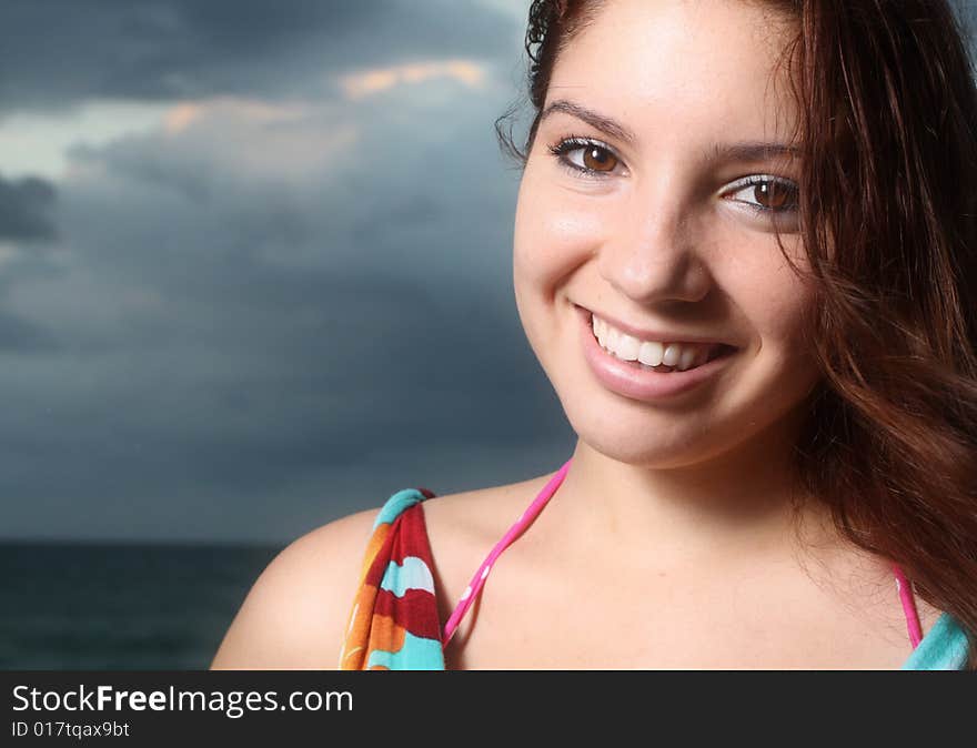 Young female smiling with cloudy sky background. Young female smiling with cloudy sky background