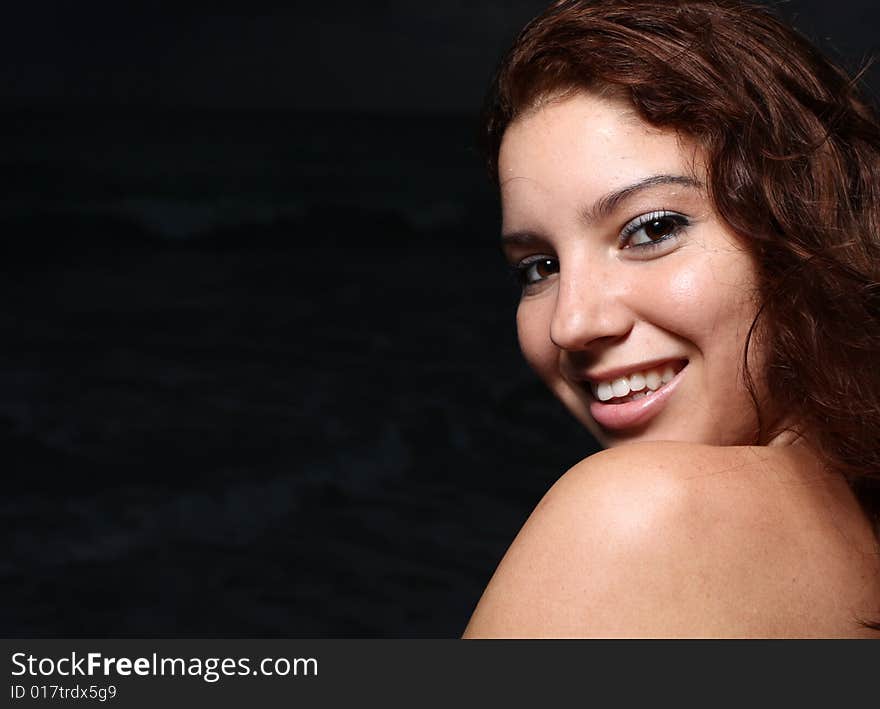 Young female smiling over her shoulder. Young female smiling over her shoulder