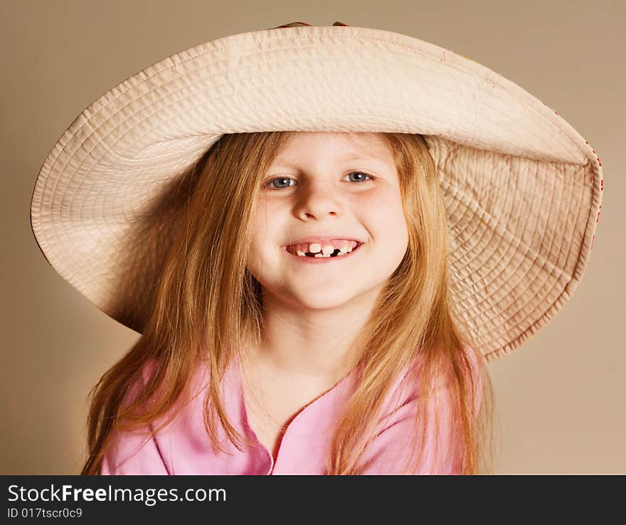 Small smiling girt wearing a hat in pink dress. Small smiling girt wearing a hat in pink dress