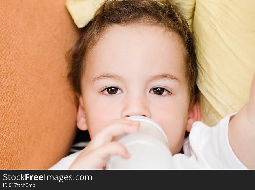 Small boy drinking milk from a bottle portrait