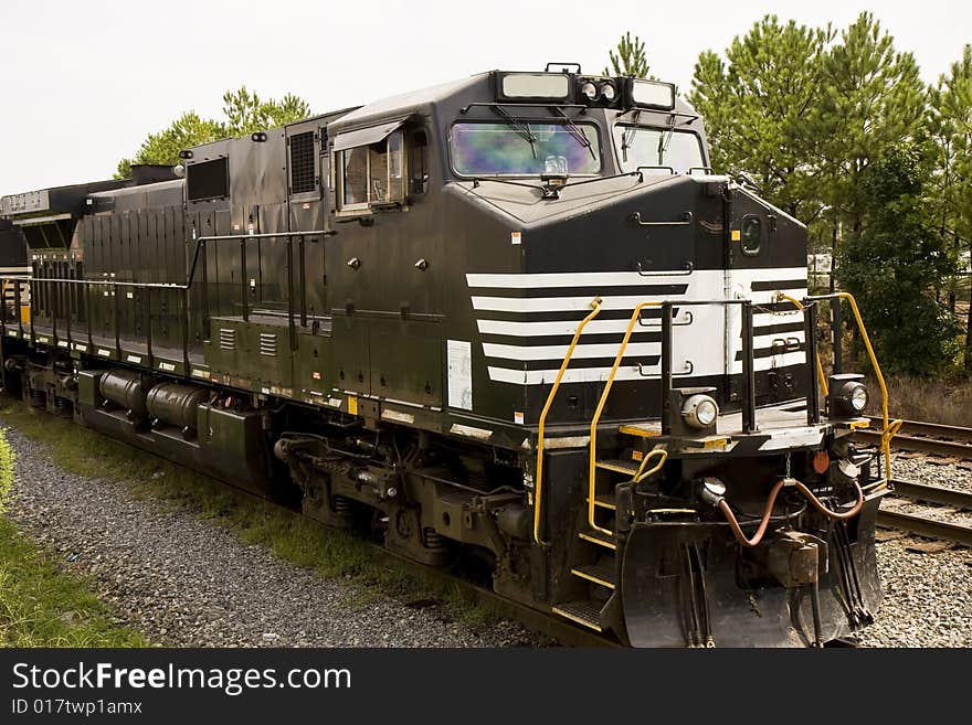 A black and white railroad locomotive on a track. A black and white railroad locomotive on a track