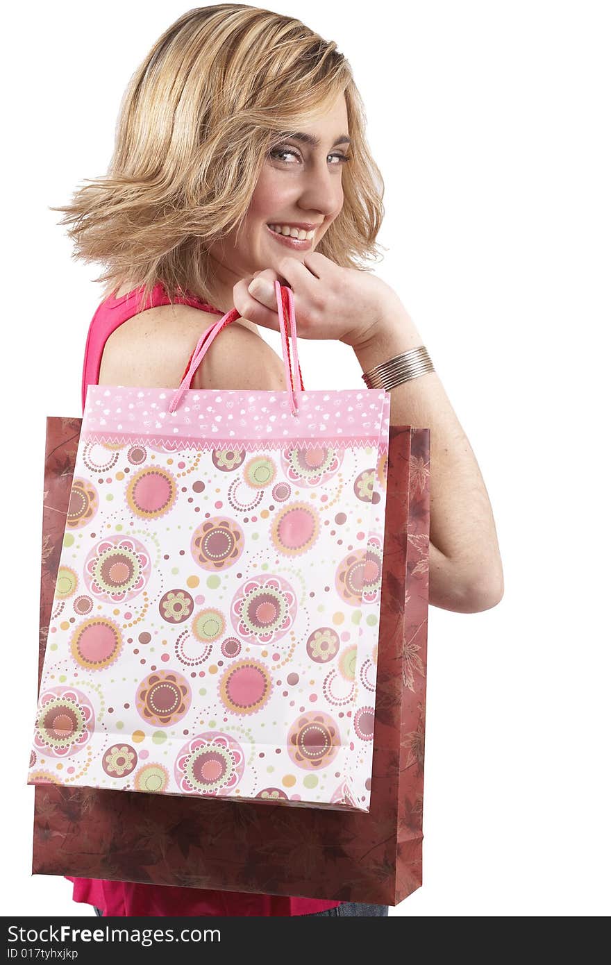 Portrait of a beautiful young blonde woman wearing a pink fashionable top and holding shopping bags over her shoulder. Isolated on white background. Portrait of a beautiful young blonde woman wearing a pink fashionable top and holding shopping bags over her shoulder. Isolated on white background