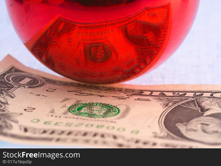 Reflection of the dollar in a glass ball.  Focus foreground glass. Reflection of the dollar in a glass ball.  Focus foreground glass