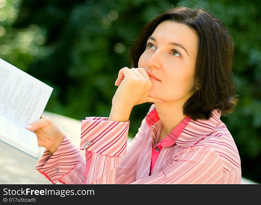 Brunet woman reading in park