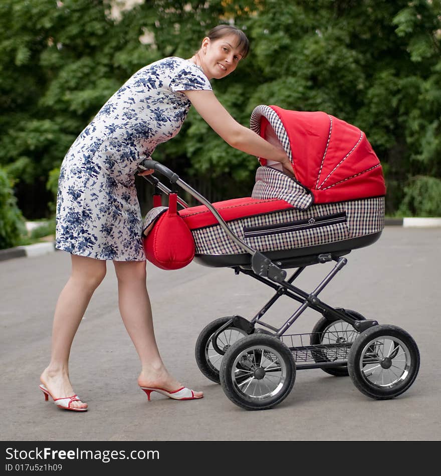 Young woman with red baby carriage. Young woman with red baby carriage