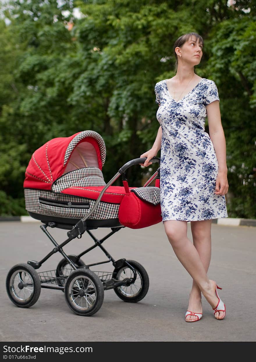 Young woman with red baby carriage. Young woman with red baby carriage