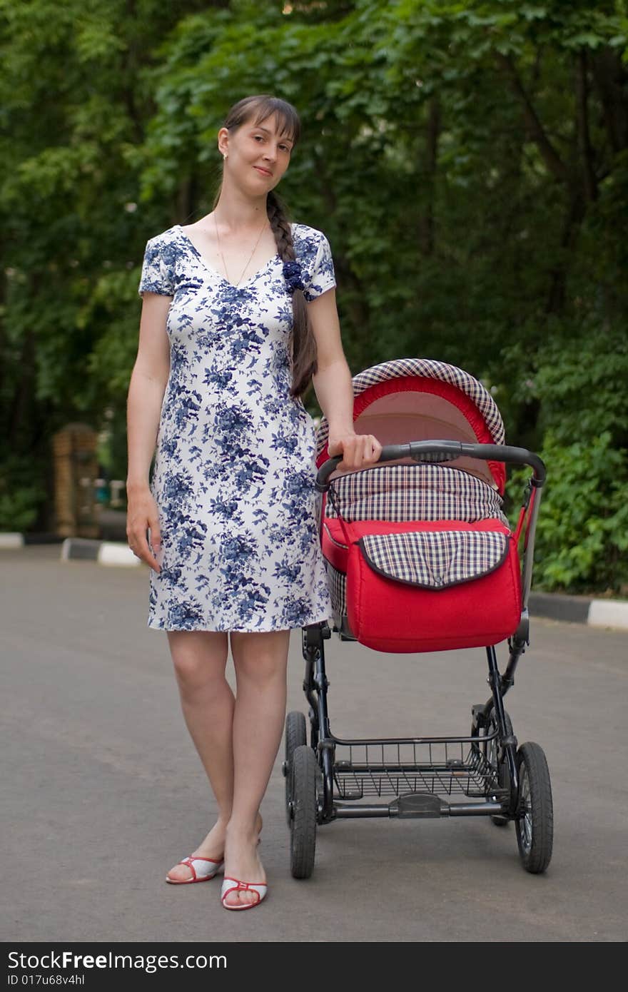 Young woman with red baby carriage. Young woman with red baby carriage