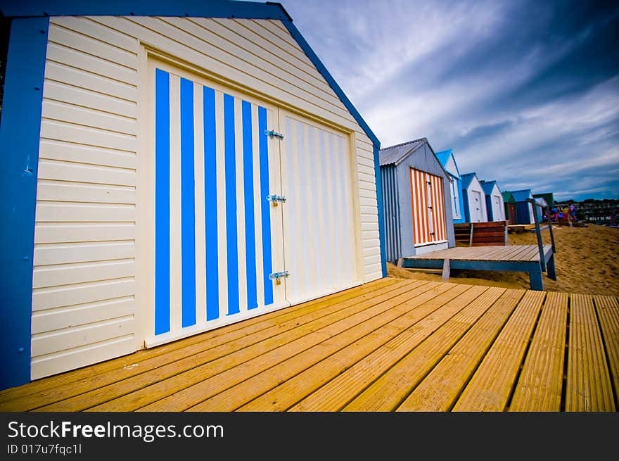 Colourful beach huts on the coastline with dramatic sky. Colourful beach huts on the coastline with dramatic sky