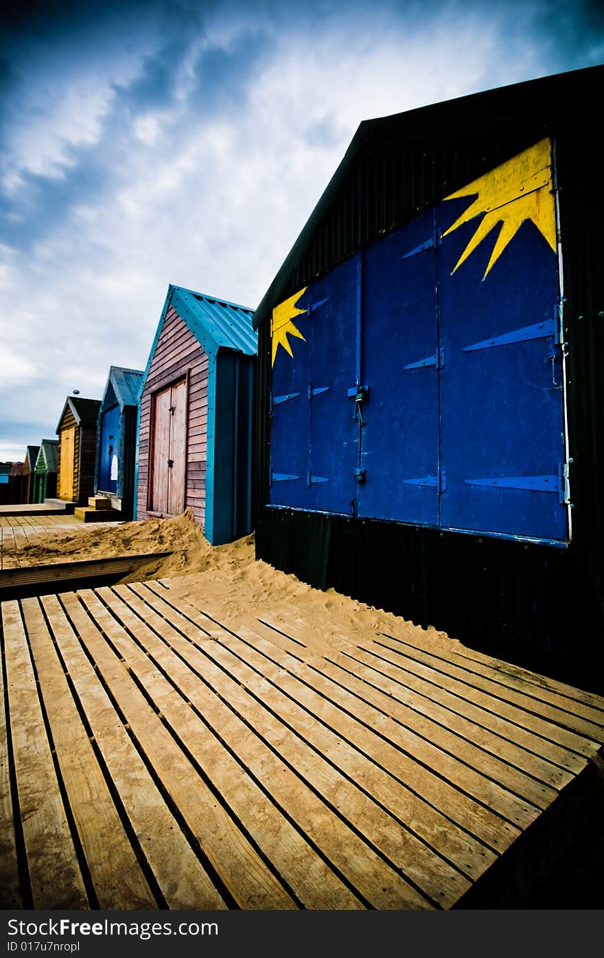 Colourful beach huts on the coastline with dramatic sky. Colourful beach huts on the coastline with dramatic sky