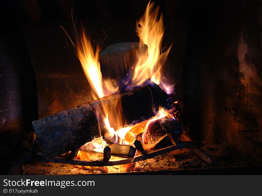 Burning wood with beautiful flames in a fireplace.