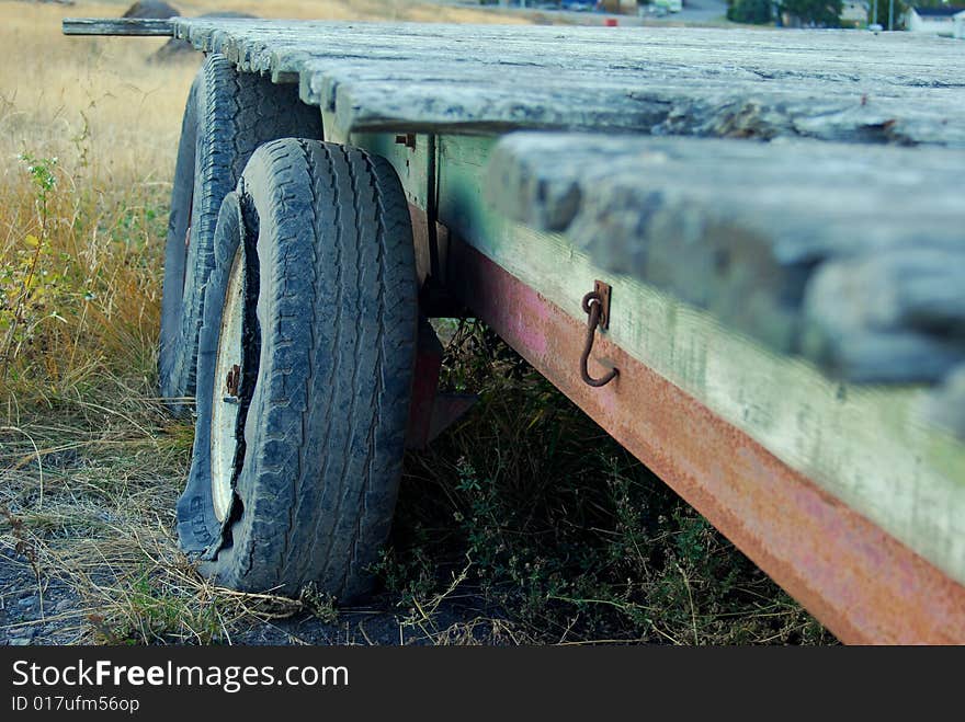 Old broken tractor hanger lying in a field. Old broken tractor hanger lying in a field