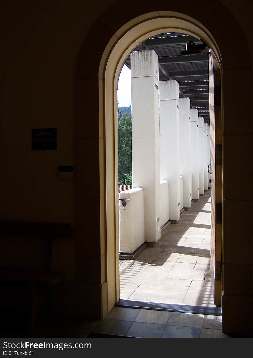 A row of white square columns through a doorway. A row of white square columns through a doorway